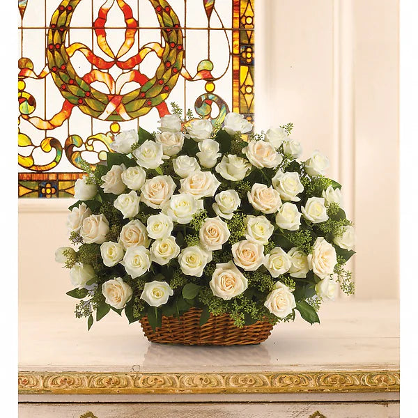 Basket of white roses in front of a stained glass window