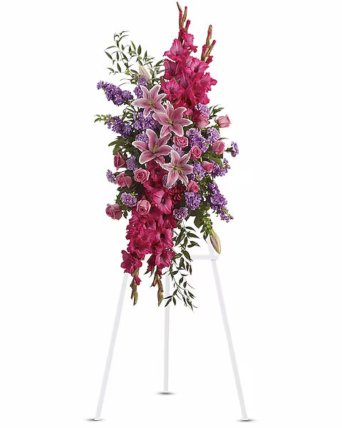 Floral arrangement on a white stand with pink and purple flowers