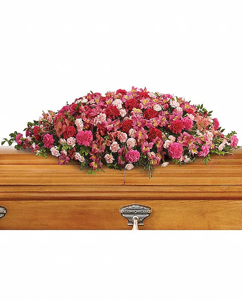 Wooden casket with vibrant floral arrangement elegantly displayed on top