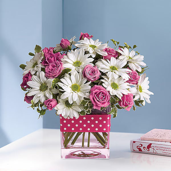 Bouquet of pink roses and white daisies in a clear vase