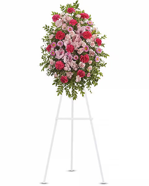 Vibrant pink and red flower display on white stand against white backdrop