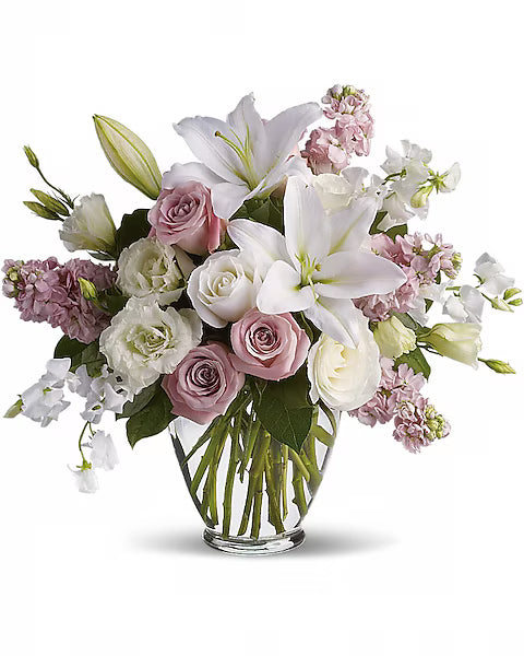 Soft-toned flower bouquet with white, blush pink, and green stems in a vase.